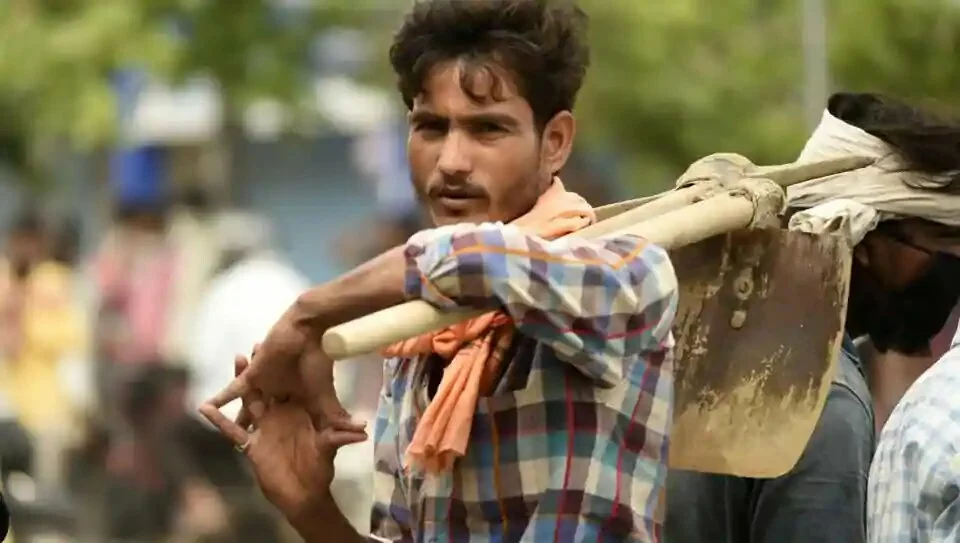 A daily wage worker holding his shovel waits for work at Labor chowk on Khandsa road, in Gurugram on Thursday.